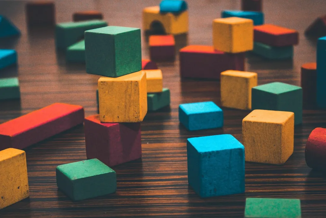 Colourful wooden blocks scattered across a dark table