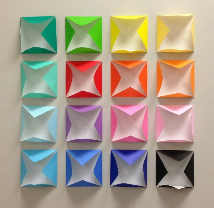 A wall grid of brightly coloured origami folds